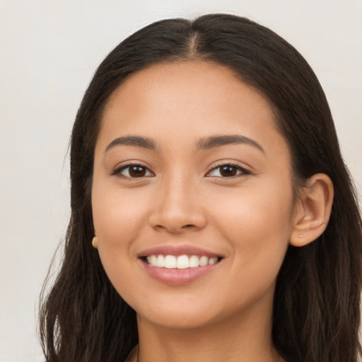 Joyful latino young-adult female with long  brown hair and brown eyes