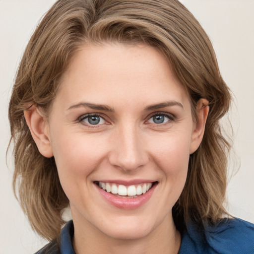 Joyful white young-adult female with medium  brown hair and blue eyes