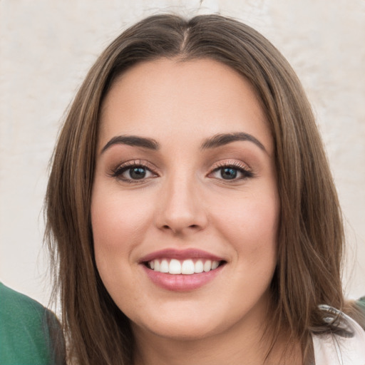 Joyful white young-adult female with long  brown hair and green eyes