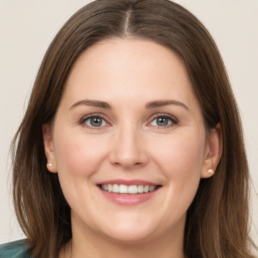 Joyful white young-adult female with long  brown hair and grey eyes