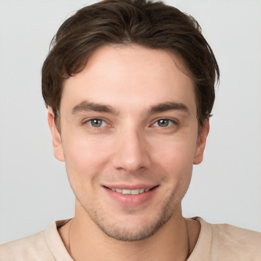 Joyful white young-adult male with short  brown hair and grey eyes