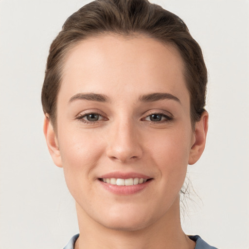 Joyful white young-adult female with short  brown hair and grey eyes