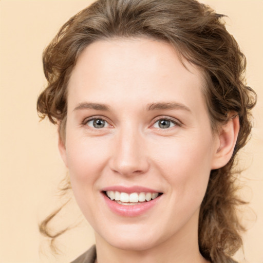 Joyful white young-adult female with medium  brown hair and green eyes