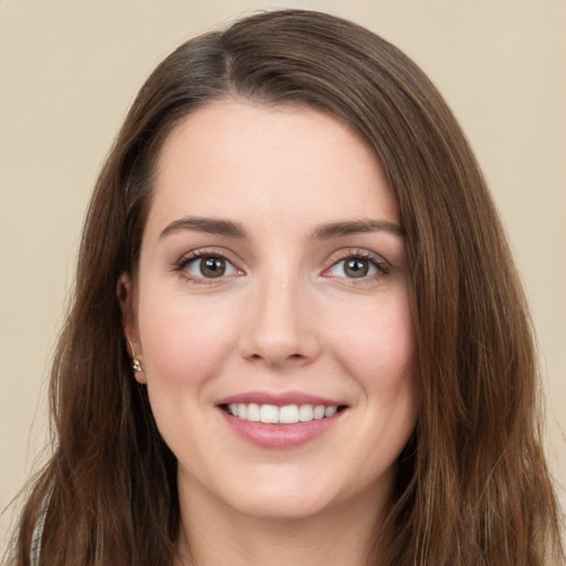 Joyful white young-adult female with long  brown hair and green eyes