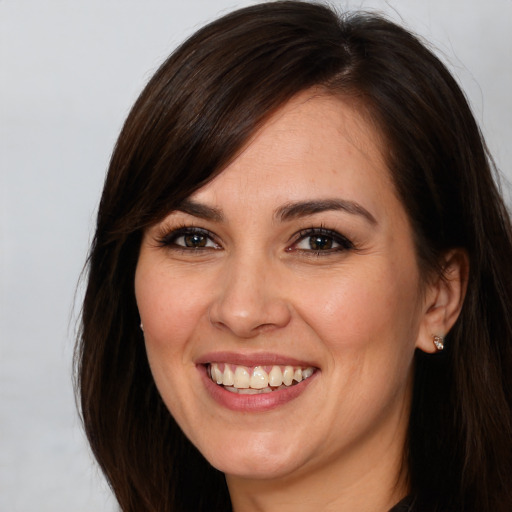 Joyful white young-adult female with long  brown hair and brown eyes