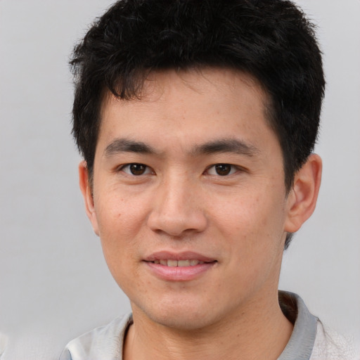 Joyful white young-adult male with short  black hair and brown eyes