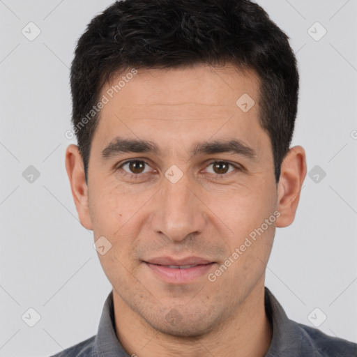 Joyful white young-adult male with short  black hair and brown eyes