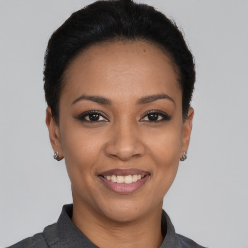 Joyful latino young-adult female with short  black hair and brown eyes