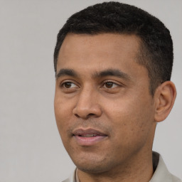 Joyful latino young-adult male with short  black hair and brown eyes