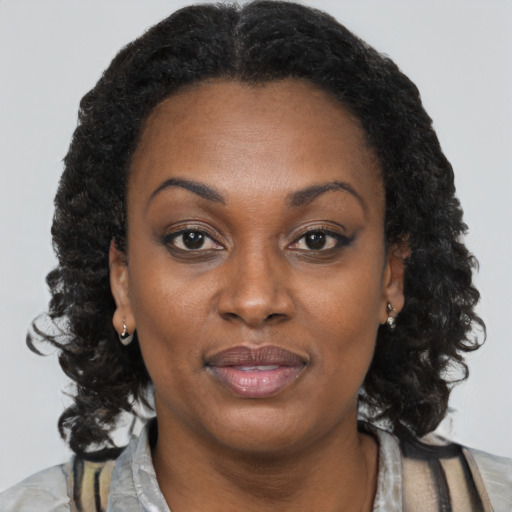 Joyful black adult female with long  brown hair and brown eyes