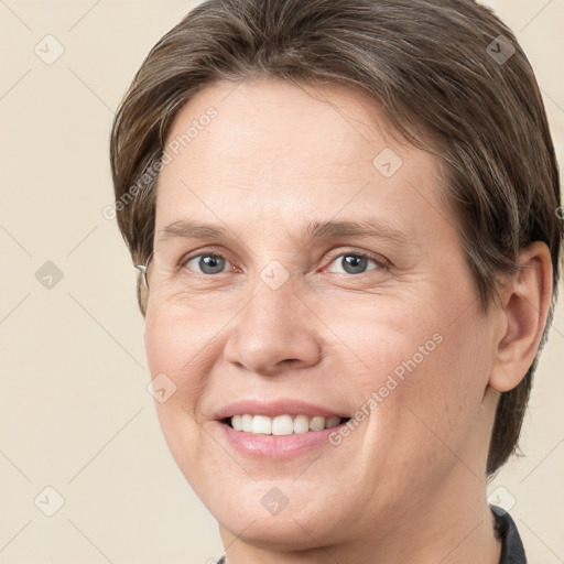 Joyful white adult female with medium  brown hair and grey eyes