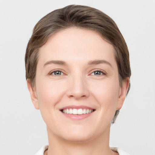 Joyful white young-adult female with short  brown hair and grey eyes