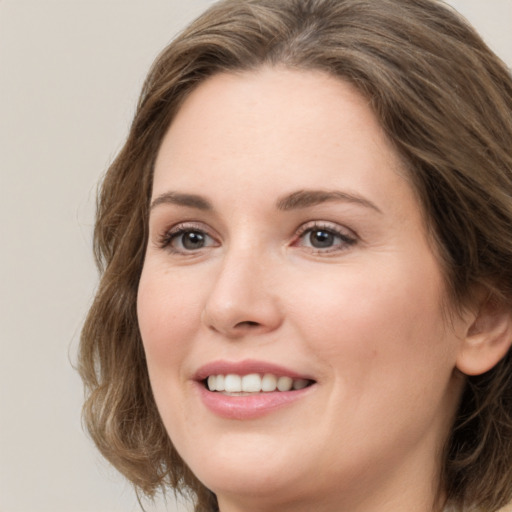 Joyful white young-adult female with long  brown hair and green eyes