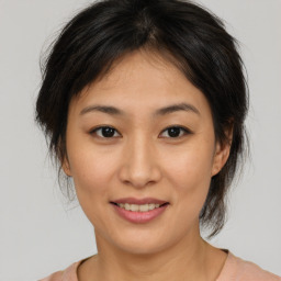 Joyful asian young-adult female with medium  brown hair and brown eyes