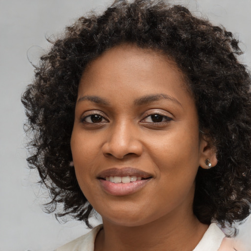 Joyful black young-adult female with medium  brown hair and brown eyes