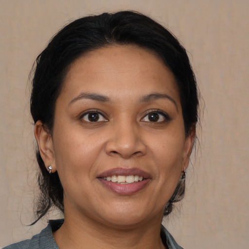 Joyful latino adult female with medium  brown hair and brown eyes
