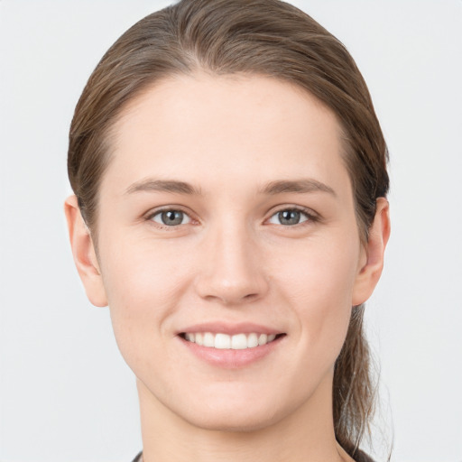 Joyful white young-adult female with medium  brown hair and grey eyes