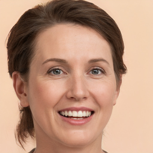 Joyful white young-adult female with medium  brown hair and grey eyes