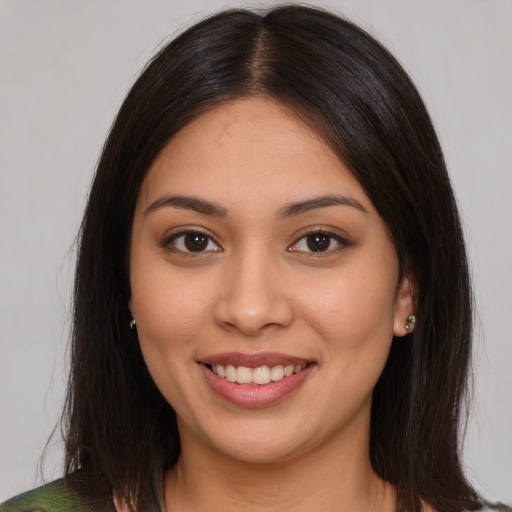 Joyful latino young-adult female with medium  brown hair and brown eyes