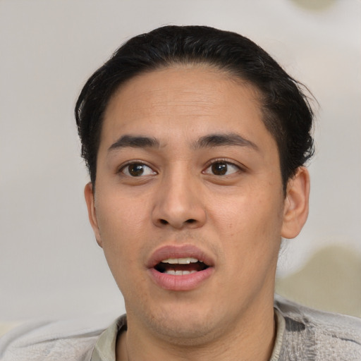 Joyful asian young-adult male with short  brown hair and brown eyes