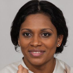 Joyful black young-adult female with medium  brown hair and brown eyes
