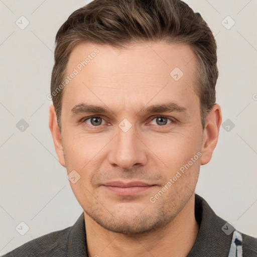 Joyful white young-adult male with short  brown hair and grey eyes