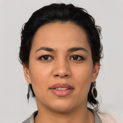 Joyful latino young-adult female with medium  brown hair and brown eyes