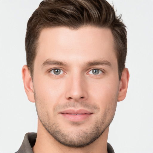 Joyful white young-adult male with short  brown hair and grey eyes