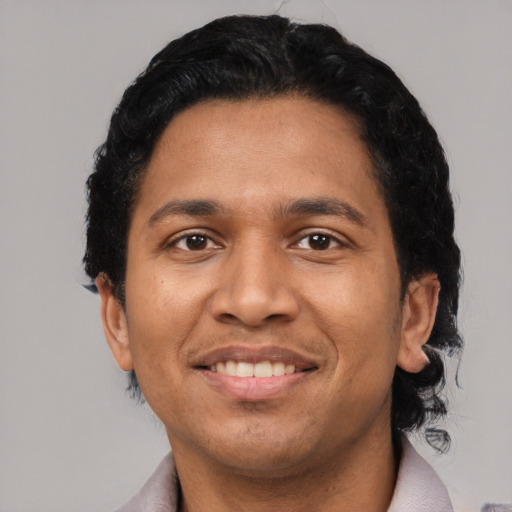 Joyful latino young-adult male with short  black hair and brown eyes