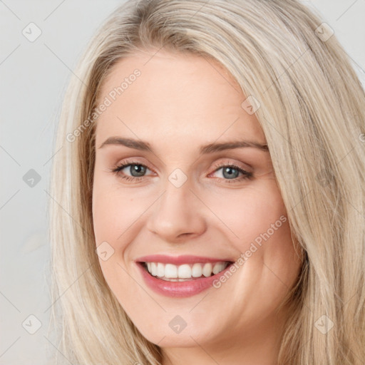 Joyful white young-adult female with long  brown hair and blue eyes