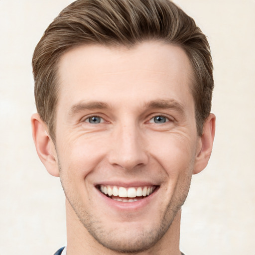 Joyful white young-adult male with short  brown hair and grey eyes