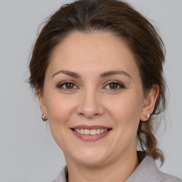 Joyful white adult female with medium  brown hair and brown eyes