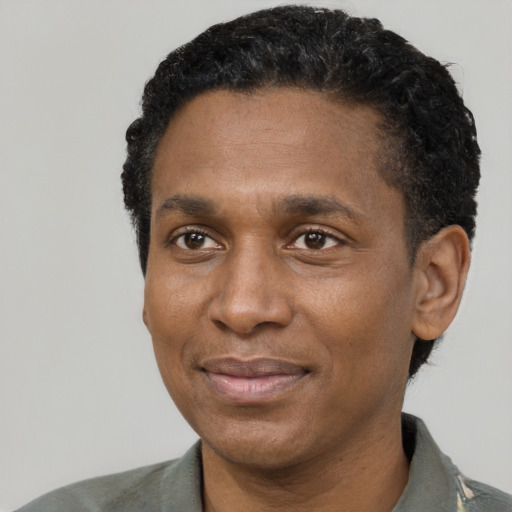 Joyful black adult male with short  black hair and brown eyes