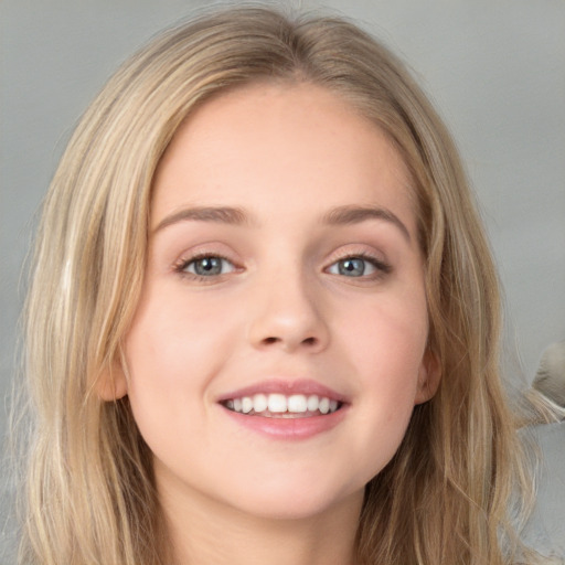 Joyful white young-adult female with long  brown hair and blue eyes