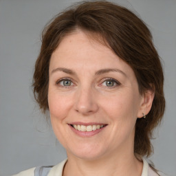 Joyful white adult female with medium  brown hair and grey eyes