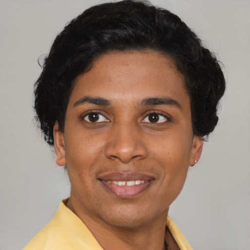 Joyful black young-adult female with short  black hair and brown eyes