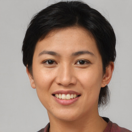 Joyful asian young-adult female with short  brown hair and brown eyes