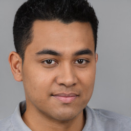 Joyful latino young-adult male with short  brown hair and brown eyes