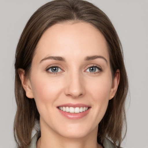 Joyful white young-adult female with medium  brown hair and grey eyes