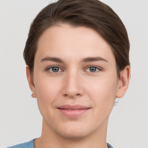 Joyful white young-adult female with short  brown hair and grey eyes