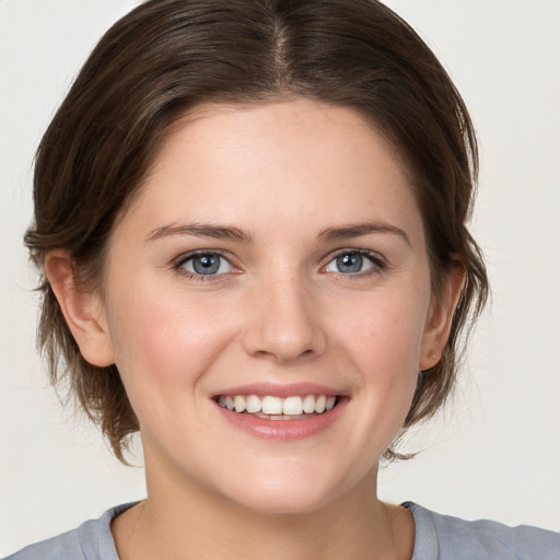 Joyful white young-adult female with medium  brown hair and blue eyes