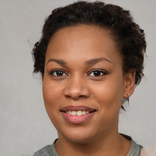 Joyful black young-adult female with short  brown hair and brown eyes