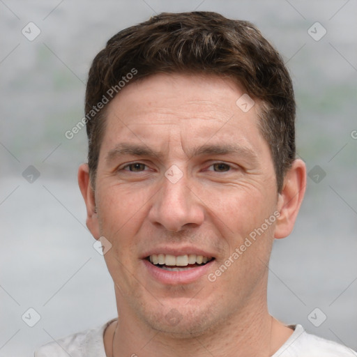 Joyful white adult male with short  brown hair and grey eyes