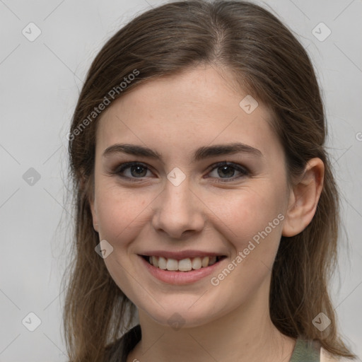 Joyful white young-adult female with long  brown hair and grey eyes