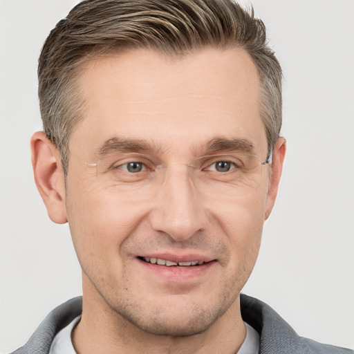 Joyful white adult male with short  brown hair and grey eyes