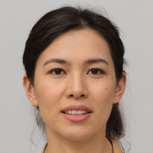 Joyful asian adult female with medium  brown hair and brown eyes