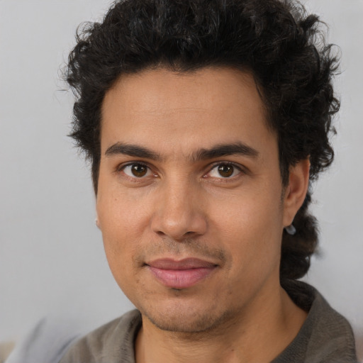 Joyful latino adult male with short  brown hair and brown eyes