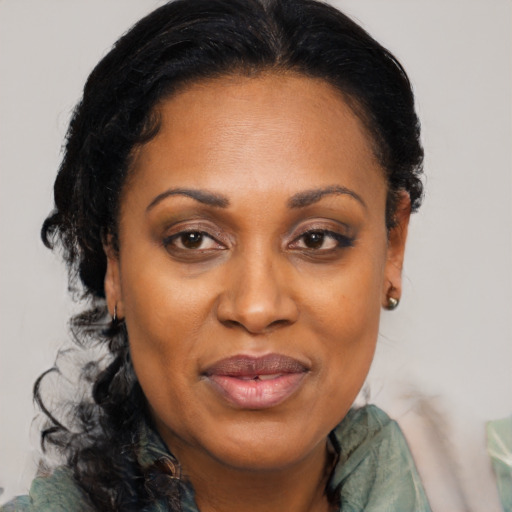 Joyful black adult female with long  black hair and brown eyes