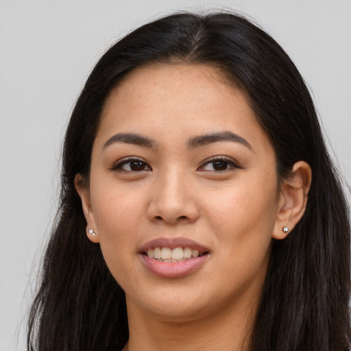 Joyful asian young-adult female with long  brown hair and brown eyes