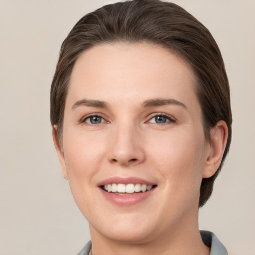 Joyful white young-adult female with short  brown hair and grey eyes